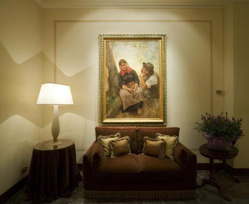 a painting of two people sitting on a couch at Hotel Francia E Quirinale in Montecatini Terme