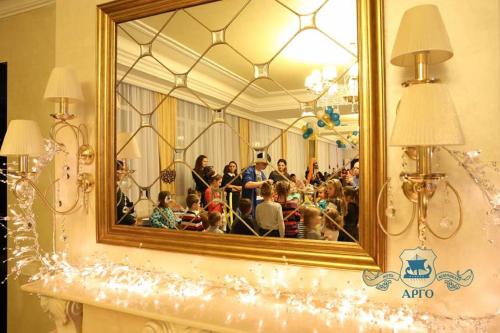 a mirror on a wall with a group of people at Argo Premium in Lviv