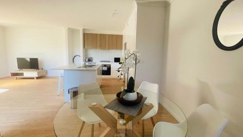 a dining room and kitchen with a glass table and chairs at Residence Of Frankcom in Blackburn