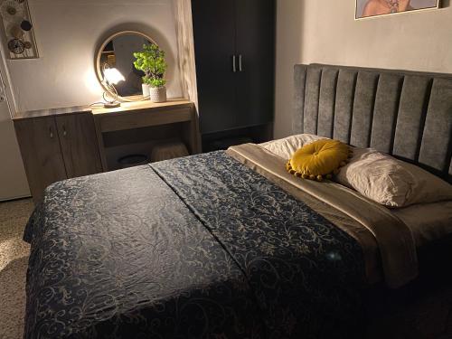 - une chambre avec un lit doté d'une couverture bleue et d'un miroir dans l'établissement Mackenzie By the sea one bed Ground floor home, à Larnaka