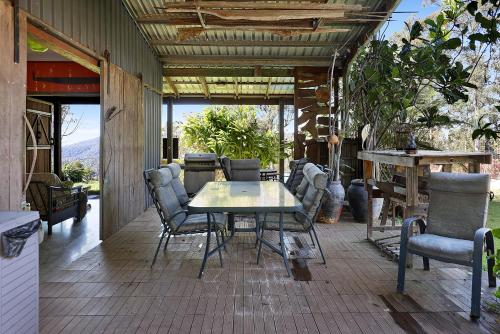 a patio with a table and chairs on a porch at Gold Coast Tree Houses in Neranwood
