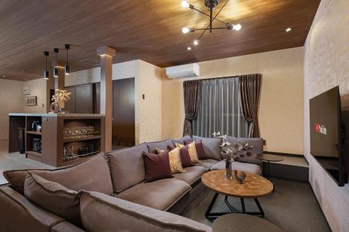a living room with a large couch and a table at JAPAVISTA Leggero in Osaka