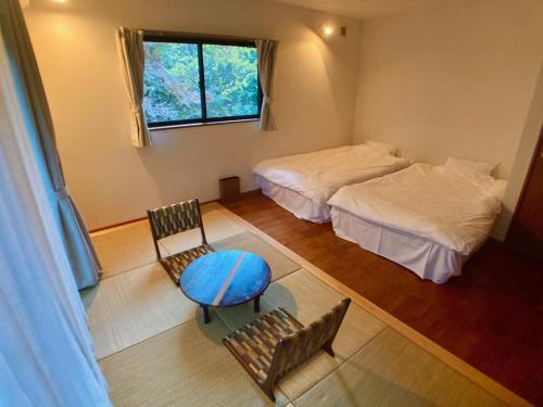 鎌倉市にあるＡＴＴＡ ＨＯＴＥＬ ＫＡＭＡＫＵＲＡ / Vacation STAY 76829のベッド2台とテーブルと椅子のある部屋