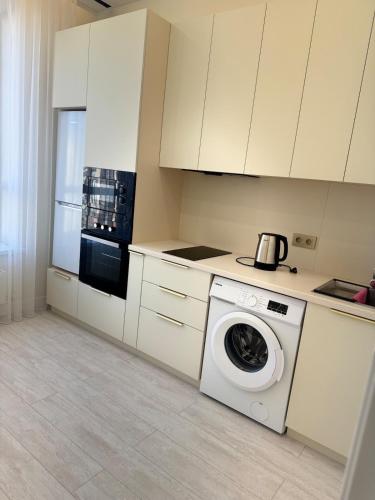 una cucina bianca con lavatrice al suo interno di Dauir 2 a Astana