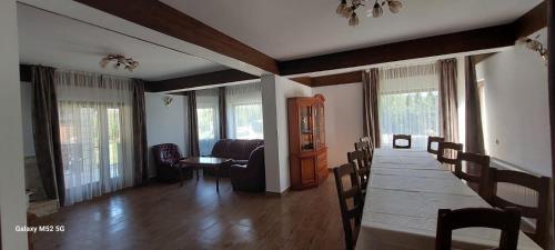 a dining room with a long table and chairs at Craii Neamtului in Almaş