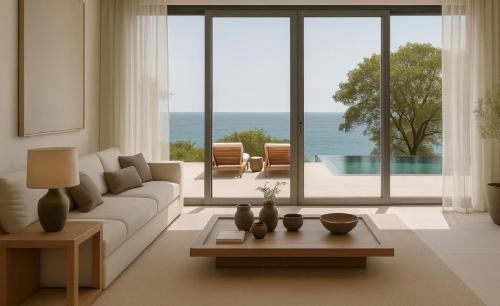 a living room with a couch and a view of the ocean at Nomade Villas in Agios Ioannis Peristeron