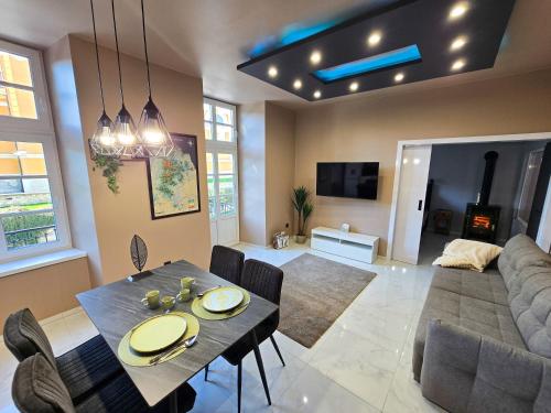 a living room with a table and a couch at Lumina Wellness Apartman in Sátoraljaújhely