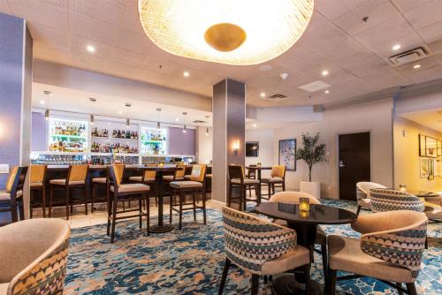 a restaurant with tables and chairs and a bar at Hilton Tampa Downtown in Tampa
