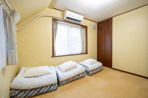 a room with two white couches and a window at Familia Kamata 1 in Tokyo