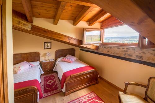 1 dormitorio con 2 camas y ventana en Apartamentos Mirador de Bareyo en Bareyo