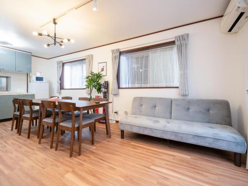 a living room with a couch and a dining room table at Familia Kamata 1 in Tokyo