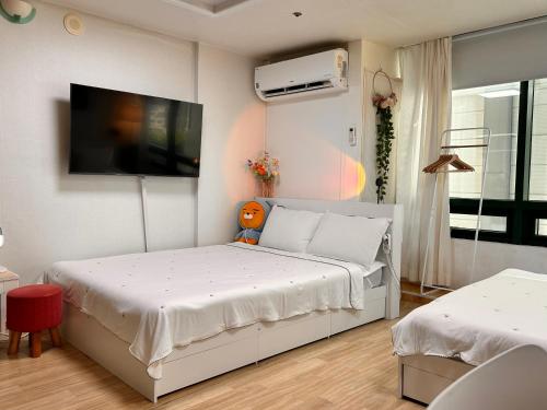 une chambre avec un lit et une télévision à écran plat dans l'établissement If House Hongdae, à Séoul