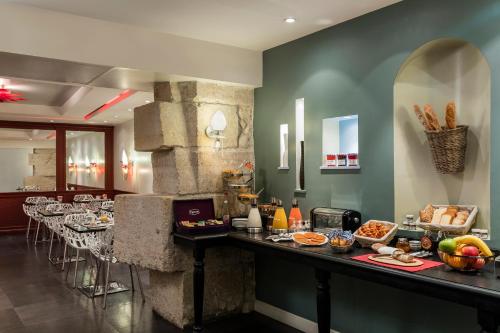 a restaurant with a buffet of food on a counter at Hotel Louvre Saint-Honoré in Paris