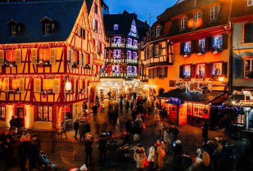 a group of people walking down a street with christmas lights at Camping ClicoChic Au Clair Ruisseau in Gerstheim