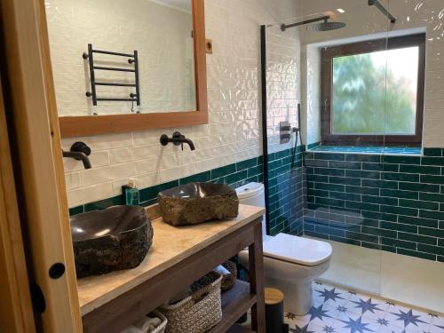 a bathroom with two sinks and a toilet at Entrenogueras in Huerta del Marquesado