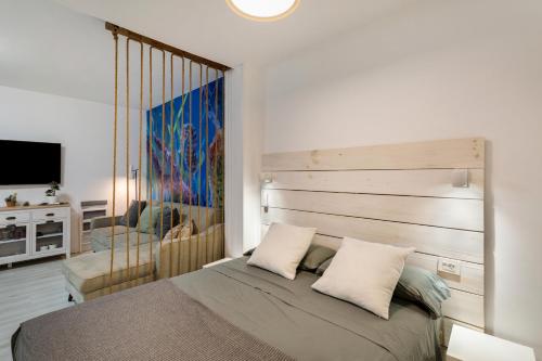 a bedroom with a bed with a wooden headboard at El Rincon de Marta in Las Palmas de Gran Canaria