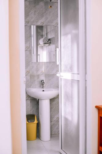 a bathroom with a sink and a mirror at Cashewnut Hotel in Mtwara