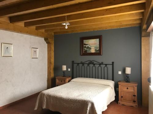 a bedroom with a bed and two night stands at Casa Rural Los Pilones in Ros