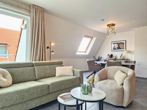 a living room with a couch and a chair at Cosy Corner 4 in Nieuwpoort