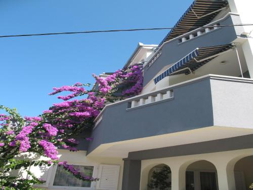 ein Gebäude mit lila Blumen auf der Seite in der Unterkunft Villa Natalie in Omiš