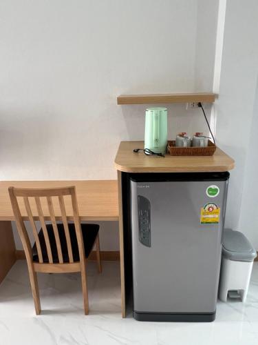 a kitchen with a table and a small refrigerator and a chair at J2 Airport Mansion in Nai Yang Beach