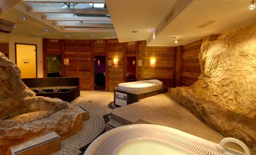 un baño grande con una gran pared de piedra. en Saaserhof Apartments, en Saas-Fee