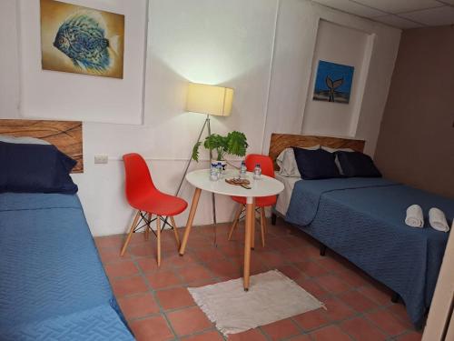 a bedroom with a bed and a table and chairs at Hostal Genoveva in San Salvador