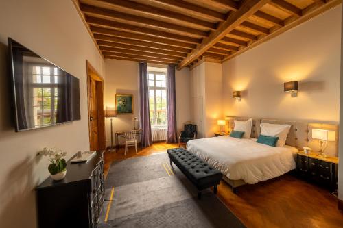 a bedroom with a bed and a bench in a room at Domaine de Montcausson in Revel