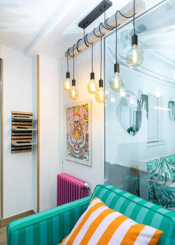 a living room with a green couch and lights at Lemon & Green GuestHome in Granada