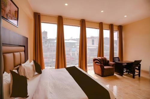 ニューデリーにあるHotel Kiara Grand - Near Mahipalpur Main Marketのベッドと机と窓があるホテルの部屋