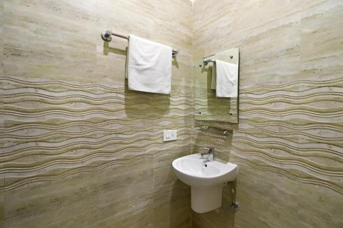 ニューデリーにあるHotel Kiara Grand - Near Mahipalpur Main Marketの洗面台、トイレ、鏡のあるバスルーム