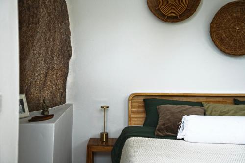 a bedroom with a bed and a white wall at Villa Verde Ko Phangan in Haad Pleayleam