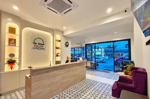 a store lobby with a counter and purple chairs at The Brown Boutique Patong in Patong Beach