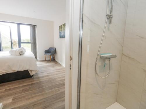 une salle de bain avec douche et une chambre avec un lit dans l'établissement Frogwell, à Sherborne