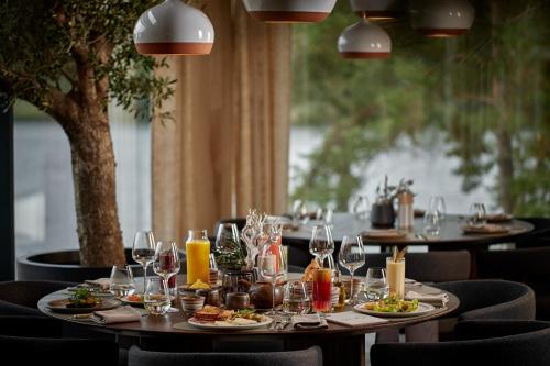 une table avec des assiettes de nourriture et des verres à vin dans l'établissement Esperanza Lake Resort, à Trakai