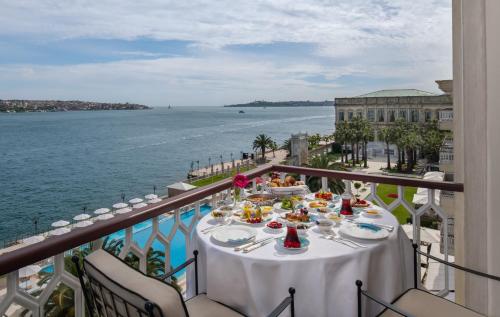 a table on a balcony with a view of the water at Çırağan Palace Kempinski Istanbul in Istanbul