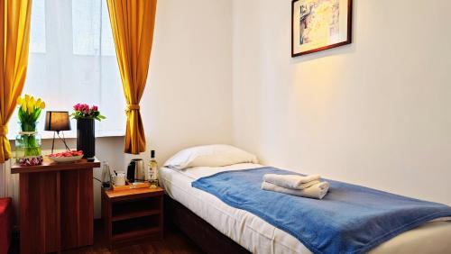 a bedroom with a bed with towels on it at Pod Wydmą in Unieście