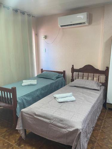 two beds in a hotel room with towels on them at Quarto do junior in Belém