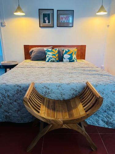 a bedroom with a large bed with a wooden bench at Auralis Villa in Flic-en-Flac