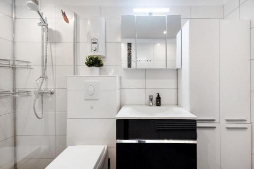 a white bathroom with a sink and a shower at Ferienwohnung Eliza in Steinhude