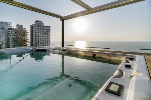 a hot tub on top of a building with the ocean at Hayarkon Apartment By the Sea in Tel Aviv