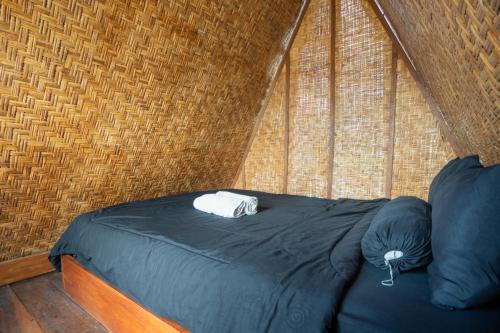 クブペンロカンにあるAnd Dita Glampingのレンガの壁のある部屋にあるベッド