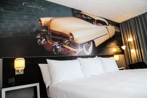 a poster of a car on the wall of a hotel room at Cadillac Motel Niagara in Niagara Falls