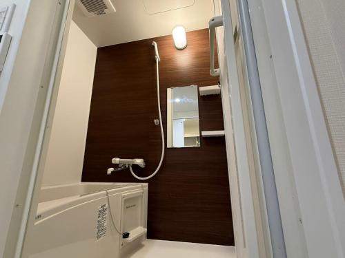 a bathroom with a shower and a mirror at Casa de sol in Miyakojima