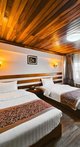 two beds in a hotel room with wooden ceilings at Eastland Hotel in Nairobi