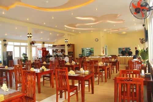Un comedor con mesas y sillas de madera. en Globiquex hotels, Phu quoc, en Phu Quoc