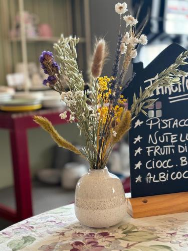a white vase with flowers in it on a table at Albergo Corte di Emma in Arzignano