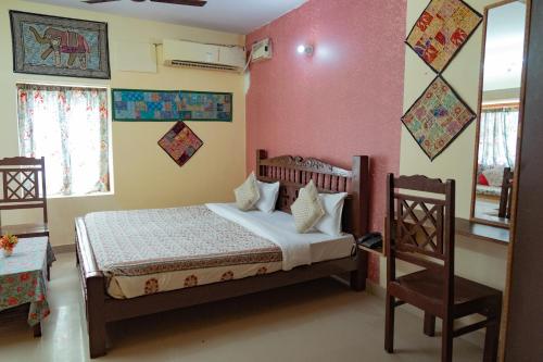 a bedroom with a bed and a chair at Hotel Rumis Jaisalmer in Jaisalmer