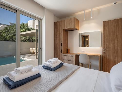 a bedroom with a bed with towels on it at Aurea Beach Villa in Kato Daratso