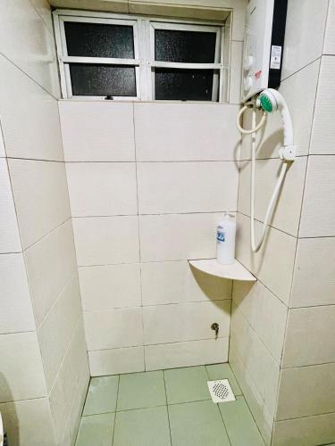 a shower in a bathroom with a window at GloryBeachResort2BedroomWifiNetflixFreeparking in Port Dickson